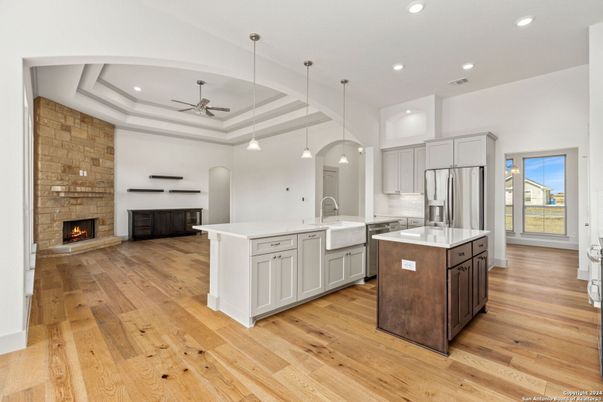 Fireplace, Interior, Kitchen, Pendant Lights, Recessed Lighting, Stainless Steel Appliances, Stone Walls, Wood Texture Flooring