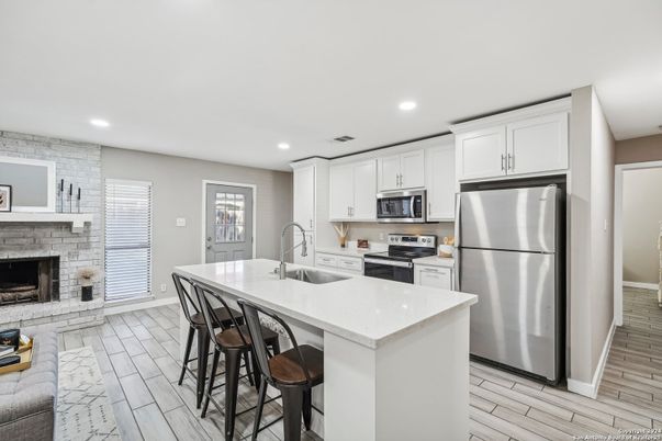 Fireplace, Interior, Kitchen, Recessed Lighting, Stainless Steel Appliances, Stone Walls, Wood Texture Flooring