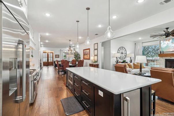 Chandelier, Dining room, Fireplace, Interior, Kitchen, Living room, Pendant Lights, Recessed Lighting, Stainless Steel Appliances, Wood Texture Flooring