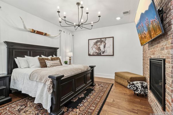 Bedroom, Chandelier, Fireplace, Interior, Recessed Lighting, Stone Walls, Wood Texture Flooring