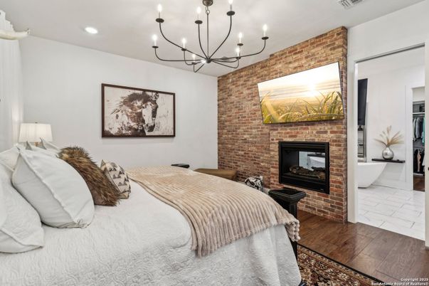 Bedroom, Chandelier, Fireplace, Interior, Recessed Lighting, Stone Walls, Wood Texture Flooring