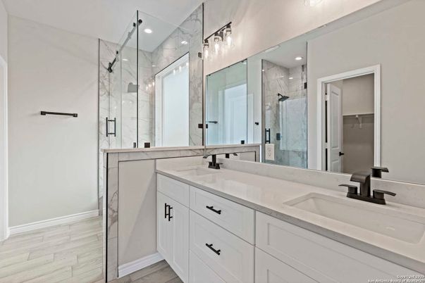Bathroom, Dual Sink Vanities, Glass Shower, Interior, Marble Walls, Recessed Lighting, Wood Texture Flooring