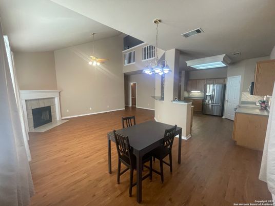 Dining room, Fireplace, Interior, Kitchen, Pendant Lights, Stainless Steel Appliances, Wood Texture Flooring