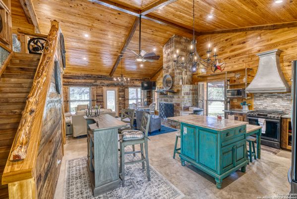 Chandelier, Dining room, Fireplace, Interior, Kitchen, Living room, Recessed Lighting, Stainless Steel Appliances, Stone Walls, Wooden Beams, Wooden Ceilings, Wooden Walls