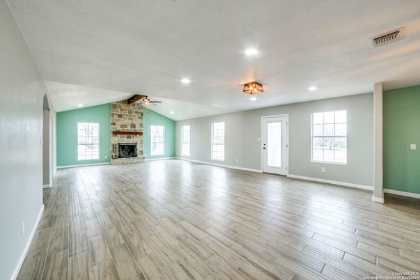 Empty room, Fireplace, Interior, Recessed Lighting, Stone Walls, Wood Texture Flooring