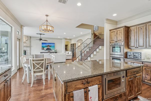 Chandelier, Dining room, Fireplace, Interior, Kitchen, Living room, Pendant Lights, Recessed Lighting, Stainless Steel Appliances, Wood Texture Flooring