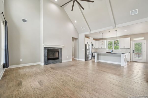 Empty room, Fireplace, Interior, Kitchen, Pendant Lights, Recessed Lighting, Stainless Steel Appliances, Wood Texture Flooring