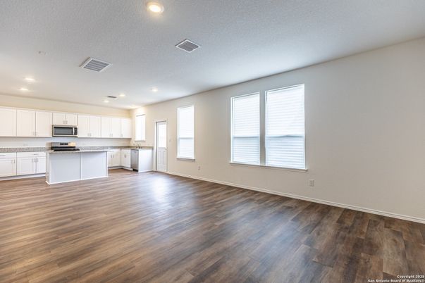 Empty room, Interior, Kitchen, Recessed Lighting, Stainless Steel Appliances, Wood Texture Flooring