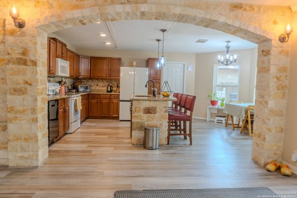 Chandelier, Dining room, Interior, Kitchen, Pendant Lights, Recessed Lighting, Stainless Steel Appliances, Stone Walls, Wood Texture Flooring