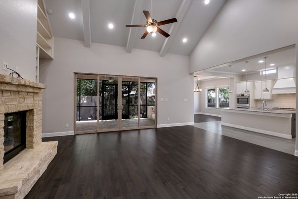 Empty room, Fireplace, Interior, Kitchen, Pendant Lights, Recessed Lighting, Stainless Steel Appliances, Wood Texture Flooring