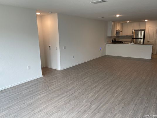 Empty room, Interior, Kitchen, Recessed Lighting, Stainless Steel Appliances, Wood Texture Flooring