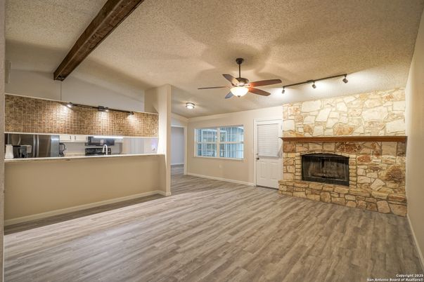Empty room, Fireplace, Interior, Kitchen, Stainless Steel Appliances, Stone Walls, Wooden Beams, Wood Texture Flooring