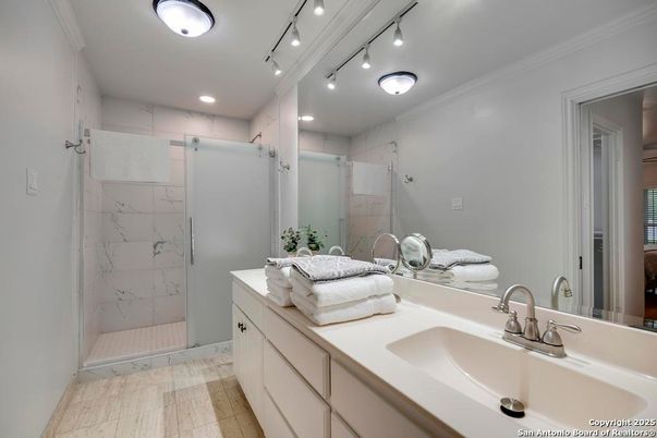 Bathroom, Dual Sink Vanities, Glass Shower, Interior, Marble Walls, Recessed Lighting, Wood Texture Flooring