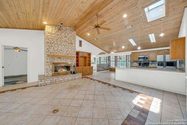 Empty room, Fireplace, Interior, Kitchen, Pendant Lights, Recessed Lighting, Stainless Steel Appliances, Wooden Ceilings