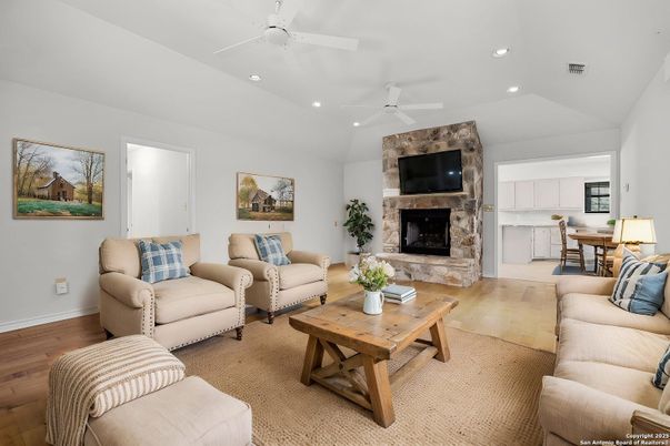 Dining room, Fireplace, Interior, Living room, Recessed Lighting, Stone Walls, Wood Texture Flooring
