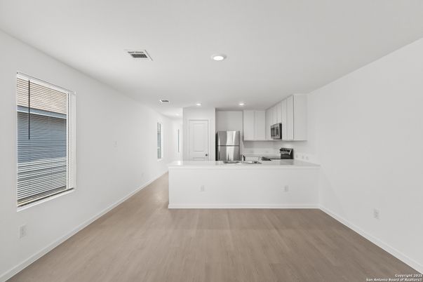 Empty room, Interior, Kitchen, Recessed Lighting, Stainless Steel Appliances, Wood Texture Flooring