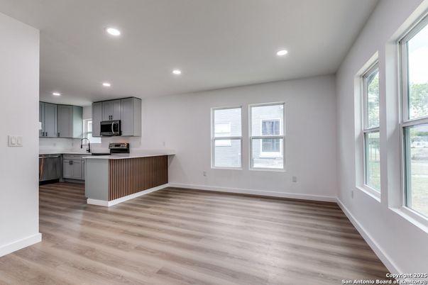 Empty room, Interior, Kitchen, Recessed Lighting, Stainless Steel Appliances, Wood Texture Flooring