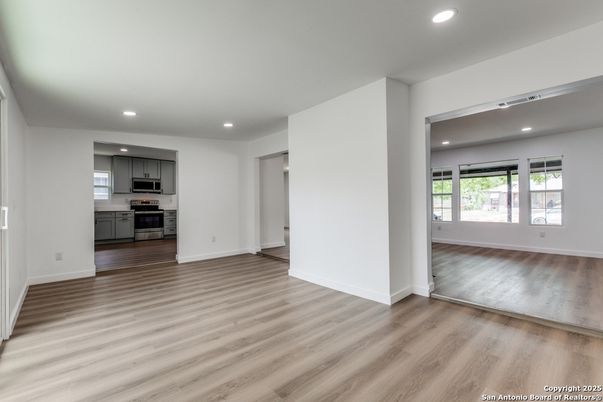 Empty room, Interior, Kitchen, Recessed Lighting, Stainless Steel Appliances, Wood Texture Flooring