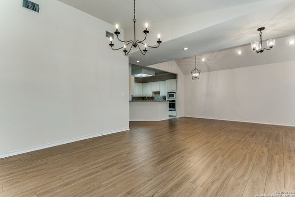Chandelier, Empty room, Interior, Kitchen, Pendant Lights, Recessed Lighting, Stainless Steel Appliances, Wood Texture Flooring