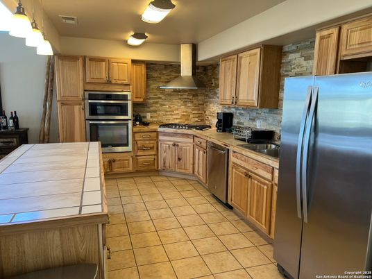 Interior, Kitchen, Stainless Steel Appliances, Stone Walls, Tile Countertops