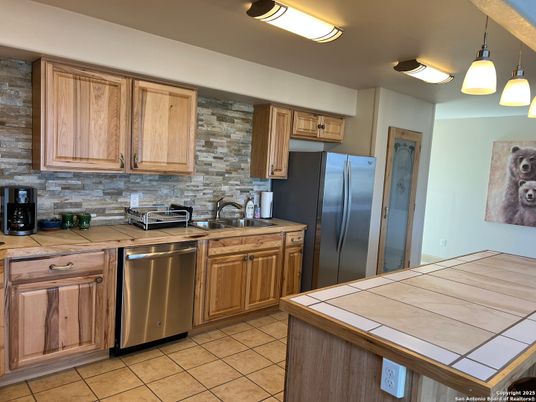 Interior, Kitchen, Pendant Lights, Stainless Steel Appliances, Stone Walls, Tile Countertops