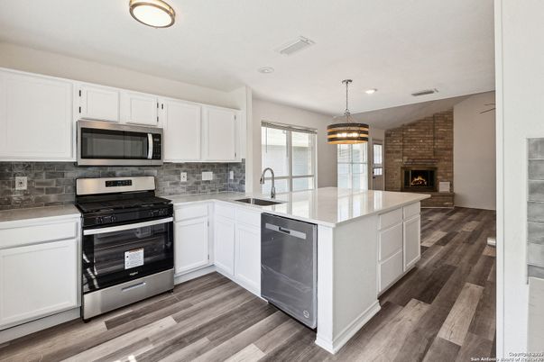Fireplace, Interior, Kitchen, Pendant Lights, Recessed Lighting, Stainless Steel Appliances, Stone Walls, Wood Texture Flooring
