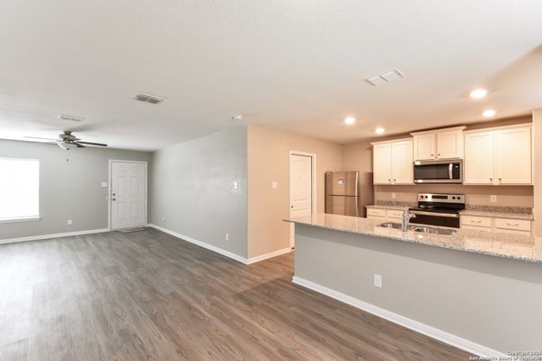 Empty room, Interior, Kitchen, Recessed Lighting, Stainless Steel Appliances, Wood Texture Flooring
