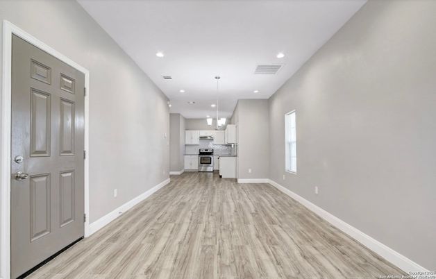 Empty room, Interior, Kitchen, Pendant Lights, Recessed Lighting, Stainless Steel Appliances, Wood Texture Flooring