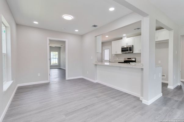 Empty room, Interior, Kitchen, Recessed Lighting, Stainless Steel Appliances, Wood Texture Flooring