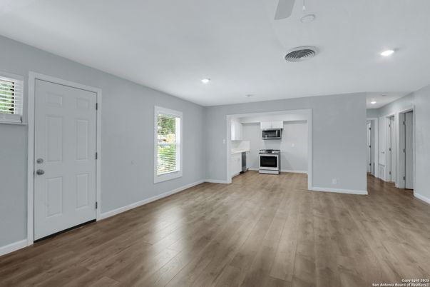 Empty room, Interior, Kitchen, Recessed Lighting, Stainless Steel Appliances, Wood Texture Flooring
