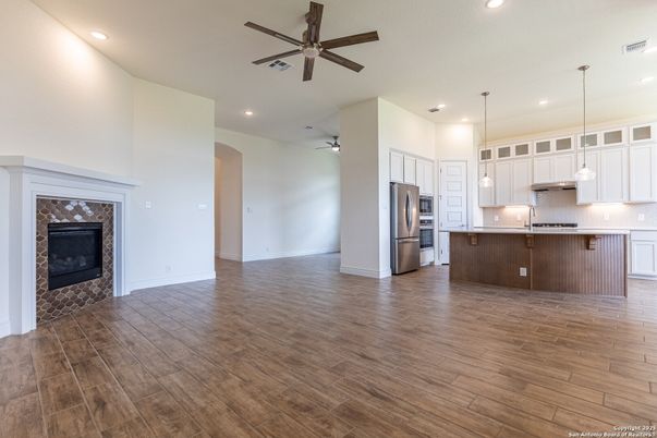 Empty room, Fireplace, Interior, Kitchen, Pendant Lights, Recessed Lighting, Stainless Steel Appliances, Wood Texture Flooring