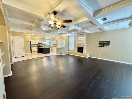 Chandelier, Empty room, Fireplace, Interior, Kitchen, Recessed Lighting, Stainless Steel Appliances, Wood Texture Flooring