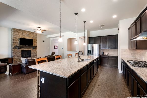 Fireplace, Interior, Kitchen, Pendant Lights, Recessed Lighting, Stainless Steel Appliances, Stone Walls, Wood Texture Flooring