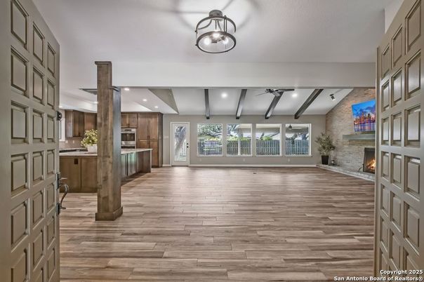 Empty room, Fireplace, Interior, Kitchen, Recessed Lighting, Stainless Steel Appliances, Stone Walls, Wood Texture Flooring
