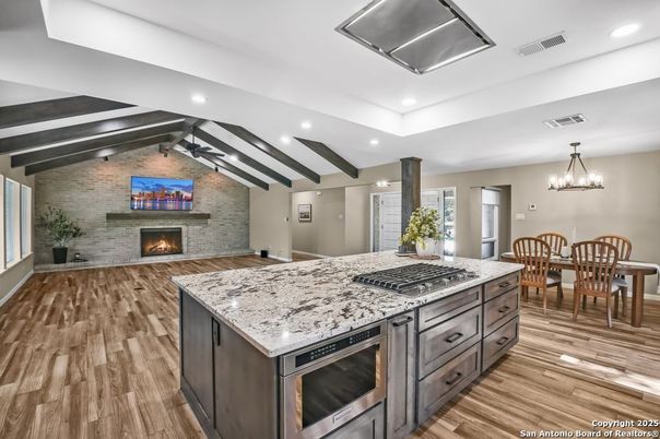 Chandelier, Dining room, Fireplace, Interior, Kitchen, Recessed Lighting, Stone Walls, Wooden Beams, Wood Texture Flooring