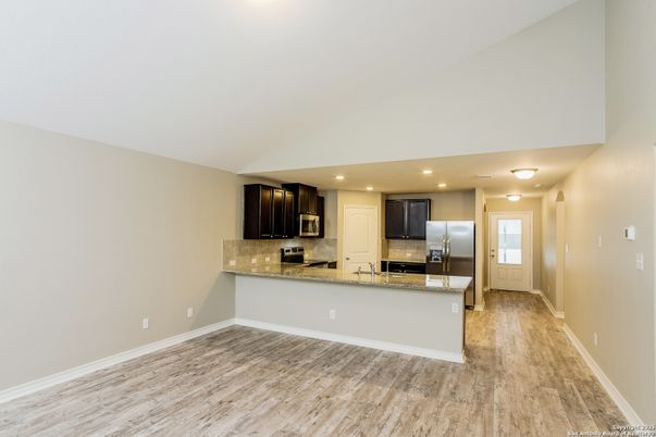 Empty room, Interior, Kitchen, Recessed Lighting, Stainless Steel Appliances, Wood Texture Flooring
