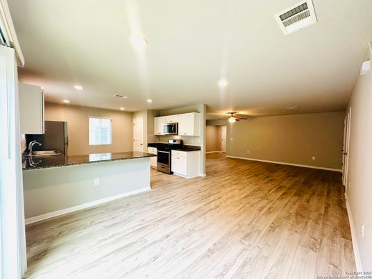 Empty room, Interior, Kitchen, Recessed Lighting, Stainless Steel Appliances, Wood Texture Flooring