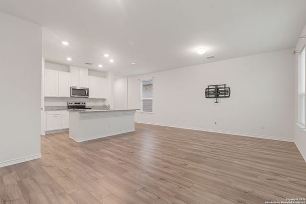 Empty room, Interior, Kitchen, Recessed Lighting, Stainless Steel Appliances, Wood Texture Flooring