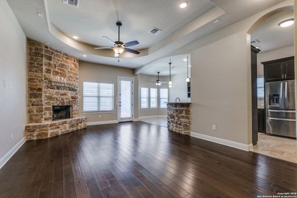 Empty room, Fireplace, Interior, Kitchen, Pendant Lights, Recessed Lighting, Stainless Steel Appliances, Stone Walls, Wood Texture Flooring