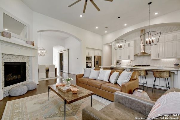 Chandelier, Fireplace, Interior, Kitchen, Living room, Pendant Lights, Recessed Lighting, Stainless Steel Appliances, Stone Walls, Wood Texture Flooring