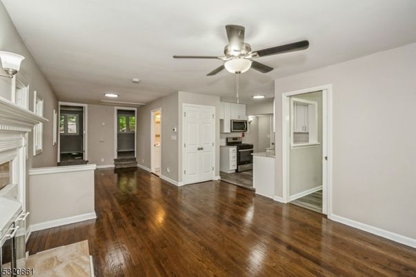 Empty room, Fireplace, Interior, Kitchen, Recessed Lighting, Stainless Steel Appliances, Wood Texture Flooring