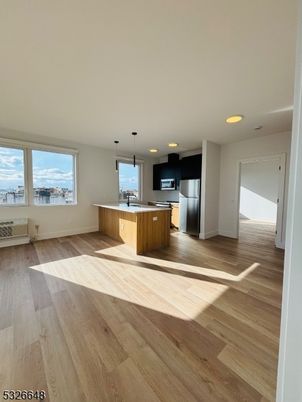 Empty room, Interior, Kitchen, Pendant Lights, Recessed Lighting, Stainless Steel Appliances, Wood Texture Flooring