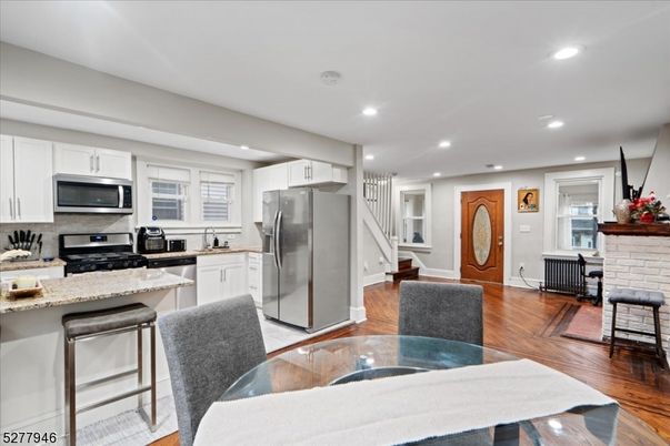 Dining room, Fireplace, Interior, Kitchen, Recessed Lighting, Stainless Steel Appliances, Stone Walls, Wood Texture Flooring