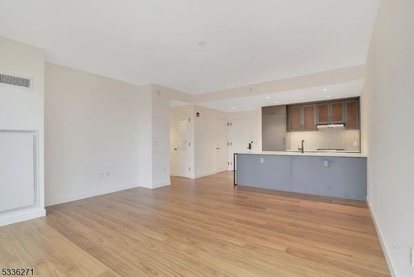 Empty room, Interior, Kitchen, Recessed Lighting, Stainless Steel Appliances, Wood Texture Flooring