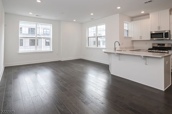 Empty room, Interior, Kitchen, Recessed Lighting, Stainless Steel Appliances, Wood Texture Flooring