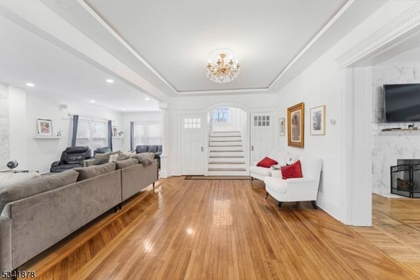 Chandelier, Fireplace, Interior, Living room, Marble Walls, Recessed Lighting, Wood Texture Flooring