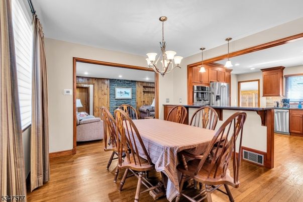 Chandelier, Dining room, Interior, Kitchen, Pendant Lights, Recessed Lighting, Stainless Steel Appliances, Wood Texture Flooring, Wooden Walls