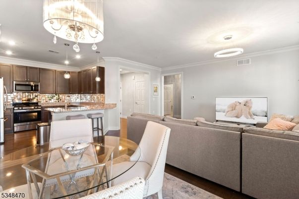 Chandelier, Dining room, Interior, Kitchen, Living room, Pendant Lights, Recessed Lighting, Stainless Steel Appliances, Wood Texture Flooring