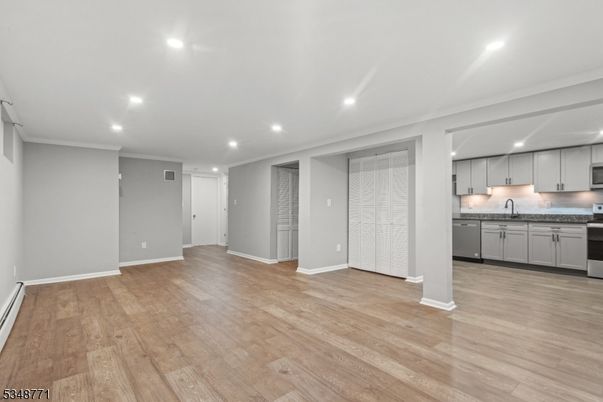 Empty room, Interior, Kitchen, Recessed Lighting, Stainless Steel Appliances, Wood Texture Flooring