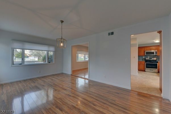 Empty room, Interior, Kitchen, Pendant Lights, Stainless Steel Appliances, Wood Texture Flooring